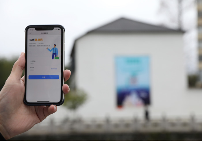 在浙江省杭州市臨安區(qū)天目山鎮(zhèn)，一名居民在“杭州健康碼”海報(bào)上掃碼申領(lǐng)個(gè)人二維碼。新華社發(fā)