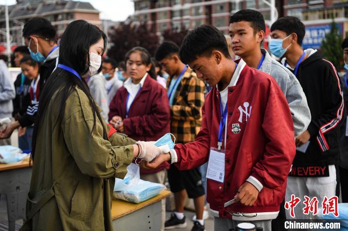 7月7日，考生在拉薩三高考點外測量體溫。　何蓬磊 攝